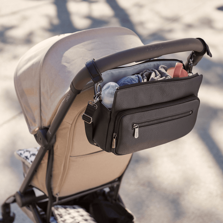 Parent enjoying hands-free strolling with innovative cup holder and phone mount accessories