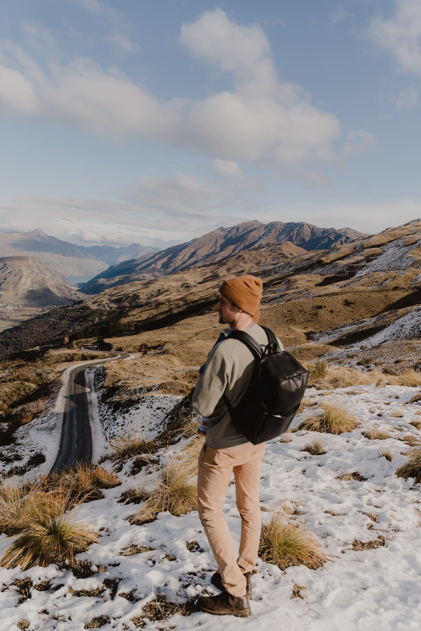 Parent using Oi Oi black dimple faux leather nappy bag backpack on an outdoor family adventure - mountains