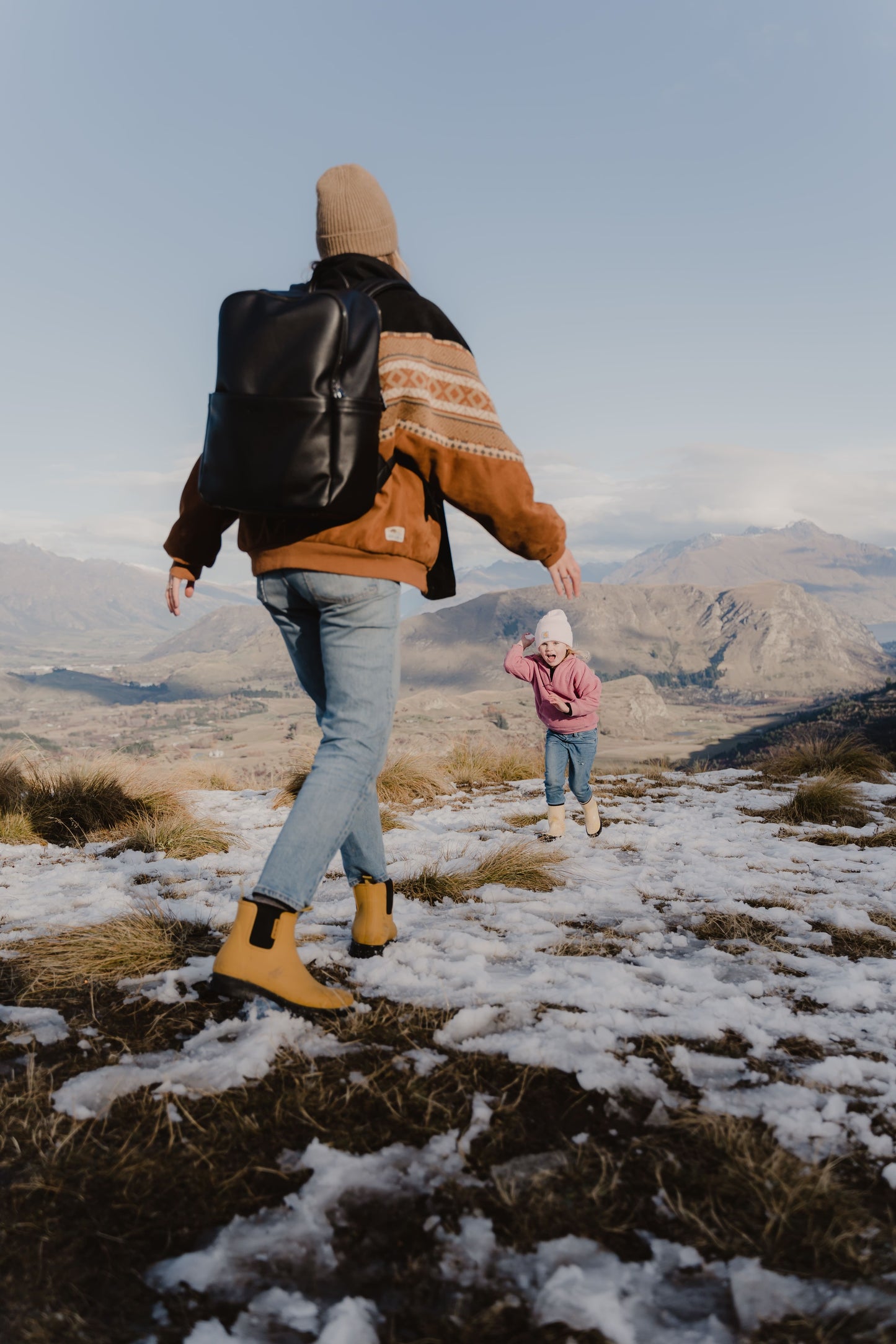 Parent using Oi Oi black dimple faux leather nappy bag backpack on an outdoor family adventure - mum and kid