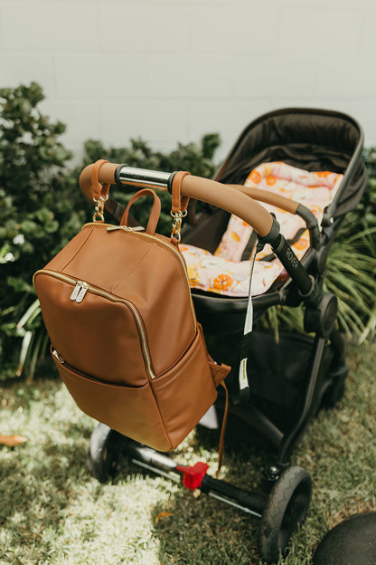 Parent using Oi Oi chestnut brown nappy bag backpack on an outdoor family adventure - pram